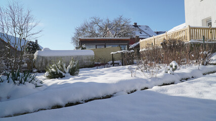 Snow covered garden on a sunny winter day near Neuhof, Germany.