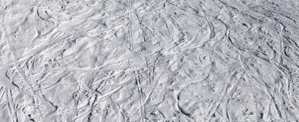 Traces of skis and snowboards on off-piste slope