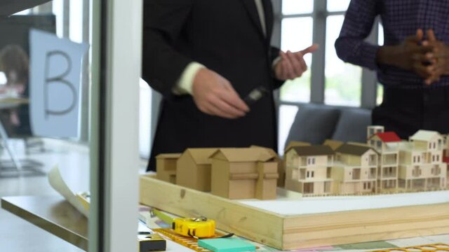 pan view of client explain requirement to black engineer in office