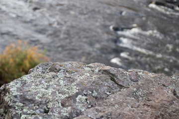 mountain river rapids with fast water and large rocky boulders in the water and the massive rocks