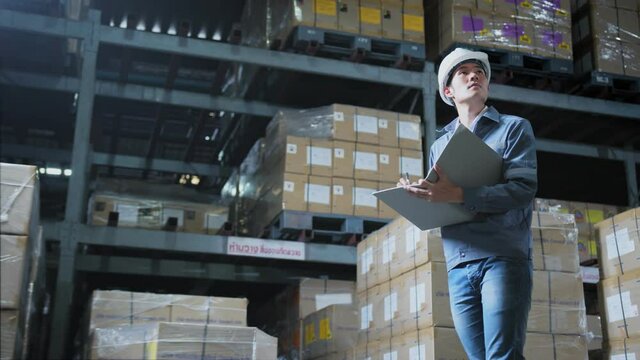 footage of engineer staff male warehouse worker in hard hat working. walking through logistics center warehouse factory construction site logistics architect businessman man builder indoors