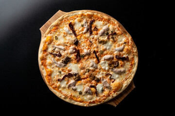 Top view of chicken and mushroom pizza with melted bright yellow cheddar cheese