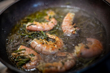 fried prawns and asparagus in a pan