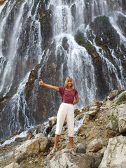 Girl in front of massive waterfall