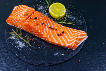 Raw salmon fillet with spices on black slate