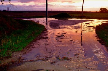 crossroads of country roads at sunset after rain
