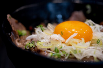Fresh chicken egg yolk topping on stir fried beef