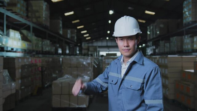 portrait of asian male professional enginner wearing uniform hardhat standing and smile with confident and cheerful in warehouse factory