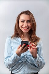 beautiful girl in a blue shirt with a phone on a white background. isolated