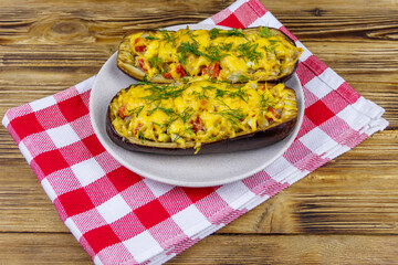 Baked stuffed eggplants on a wooden table. Healthy food and dieting concept