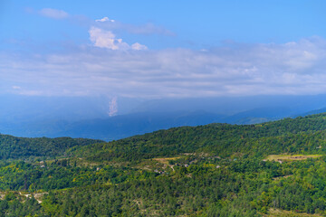 landscape with mountains. panoramic view of the mountain valley where people live in the villages. a lot of vegetation, greenery of different shades. far to the horizon, blue mountains in the haze