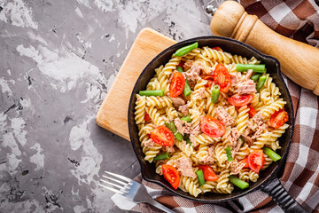 delicious traditional Italian pasta with tuna on a dark rustic stone background