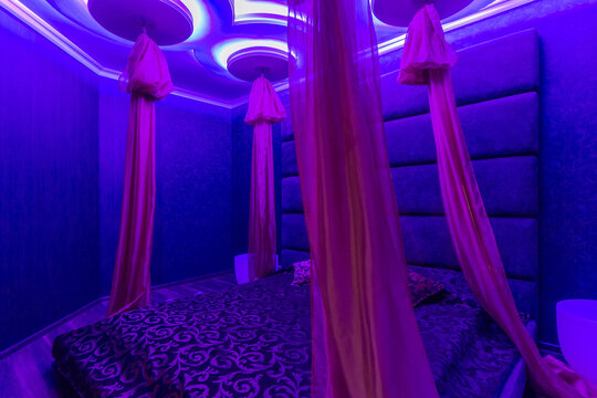 Romantic lounge, violet light color. Oriental style and a baldachin.