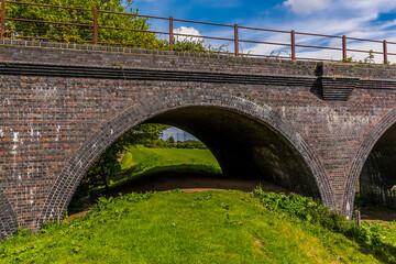 Fototapeta na wymiar A view through an arch of the abandoned railway viaduct at Fledborough, Nottinghamshire in springtime