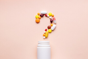 medicine pills question mark symbol isolated over pink background. medical decision concept