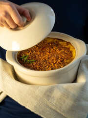 Mac and cheese, baked macaroni pasta in cheesy creamy milk butter sauce american style with breadcrumbs crust. Easy comfort food homemade family recipe. Baking dish with hot casserole in male hands.