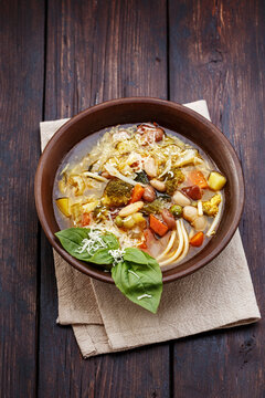 Vegetable italian minestrone soup in rustic style on old wooden table