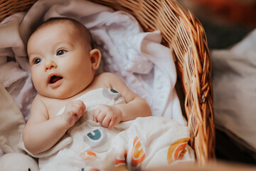 Portrait of a cute active baby lying in a crib smiling and looking at the camera. Copy space, Happy motherhood concept
