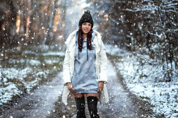 beautiful young girl in the winter forest, snow is falling. Concept for Christmas holidays, new year, winter, vacations.