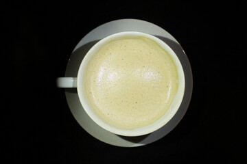 Foam from coffee in a mug on a dark background