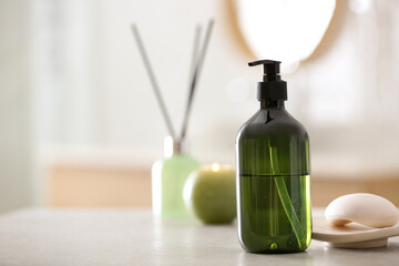 Green soap dispenser on white countertop in bathroom. Space for text