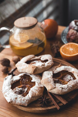 Fresh cookies with fruit orange jelly and mint on plate over rustic wooden background