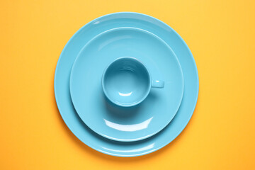 New ceramic dishware on yellow background, top view