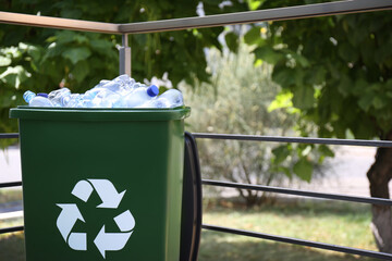 Many used plastic bottles in trash bin outdoors. Recycling problem