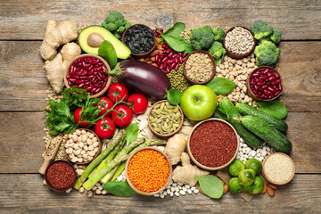 Different vegetables, seeds and fruits on wooden table, flat lay. Healthy diet