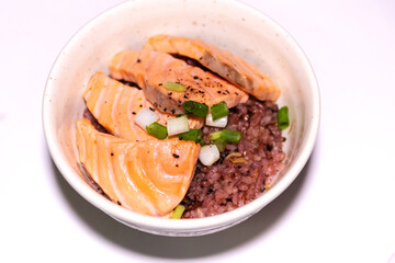 Salmon aburi don with rice in a bowl isolated on white background. 