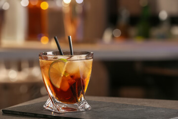 Cuba Libre cocktail on table in bar. Space for text
