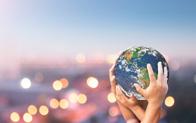 Earth Day concept: Family hands holding earth global blurred city night background. Elements of this image furnished by NASA