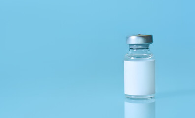 Vial with a vaccine on a blue background. Coronavirus vaccine.The concept of medicine, healthcare and science.Сopy space.