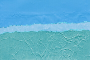 Fototapeta premium Blue torn paper collage close-up. Texture made from various paper and cardboard parts. Damaged old paper background. Vintage blank wallpaper. Material design backdrop.