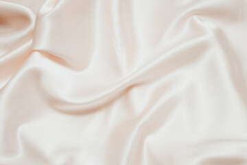 Powdery pink texture of silk, satin. Shiny fabric background.