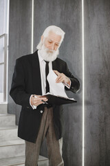 Close up portrait of old-fashioned man. Elegant man at the office. Senior with a documents.