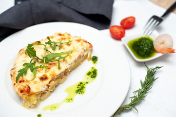 potato gratin with shrimps and rucola