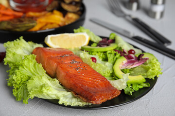 Tasty cooked salmon and fresh salad served on grey table. Healthy meals from air fryer