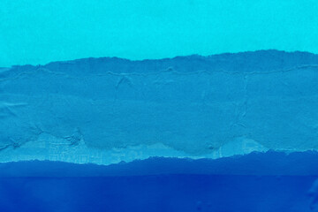 Blue torn paper collage close-up. Texture made from various paper and cardboard parts. Damaged old paper background. Vintage blank wallpaper. Material design backdrop.