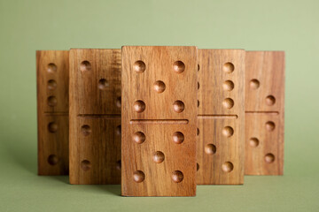 Wooden domino tiles with pips on green background