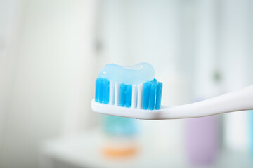 Fototapeta na wymiar Brush with toothpaste on blurred background, closeup