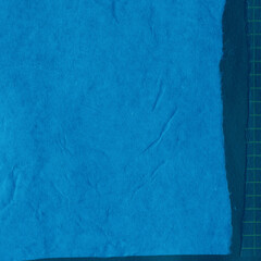 Blue torn paper collage close-up. Texture made from various paper and cardboard parts. Damaged old paper background. Vintage blank wallpaper. Material design backdrop.