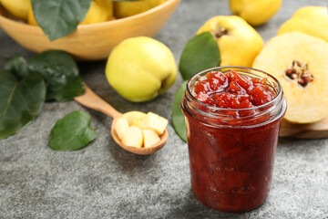 Delicious quince jam on grey table, closeup