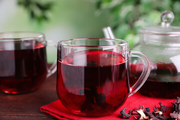 Freshly brewed hibiscus tea on wooden table, closeup