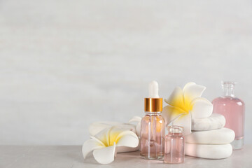 Beautiful composition with aroma oil and spa stones on marble table. Space for text