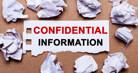 CONFIFENTIAL INFORMATION written on white paper on a light brown background.