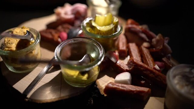 smoked sausages with sauce.Smoked sausages with sauce and bacon on a dark background. Assorted meat.