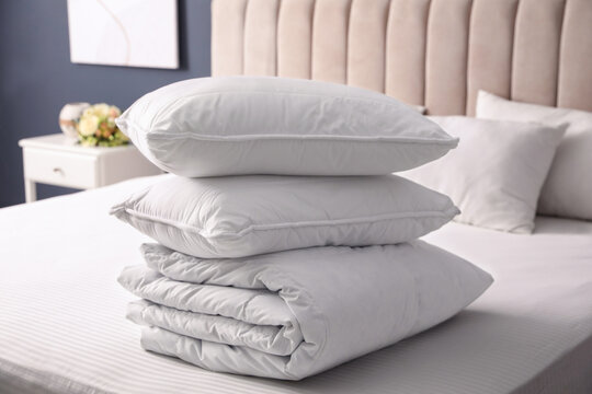 Soft folded blanket and pillows on bed indoors