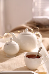 Obraz na płótnie Canvas White tray with ceramic tea set on bed