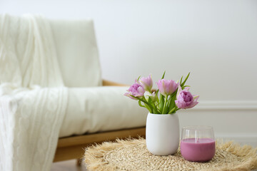 Vase with beautiful flowers and candle on table indoors, space for text. Interior elements
